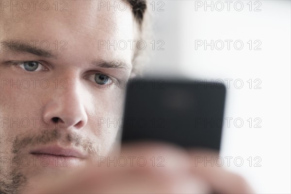 Close-up of mid-adult man texting.