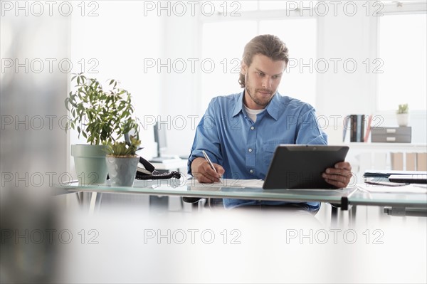 Mid-adult businessman working in office.