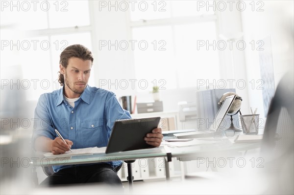 Mid-adult businessman working in office.