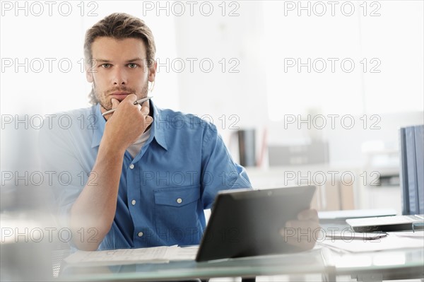 Portrait of mid-adult businessman working in office.