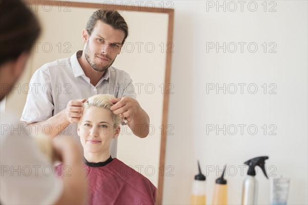 Hairdresser combing woman's hair.