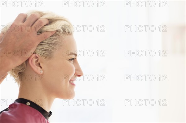 Hairdresser styling woman's hair.