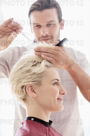 Hairdresser cutting woman's hair.