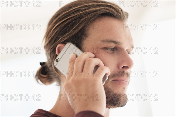 Mid-adult man talking on phone.