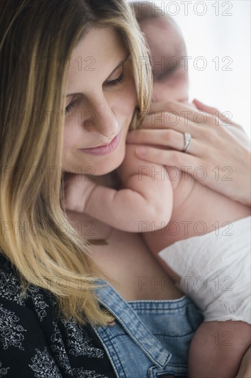 Mother holding baby girl (2-5 months) in her arms