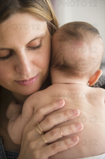 Mother holding baby girl (2-5 months) in her arms
