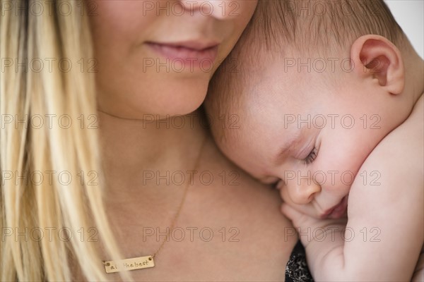 Baby girl (2-5 months) sleeping on mother's shoulder