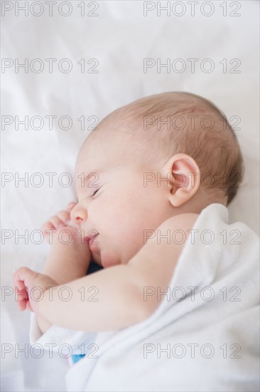 Baby girl (2-5 months) sleeping on bed
