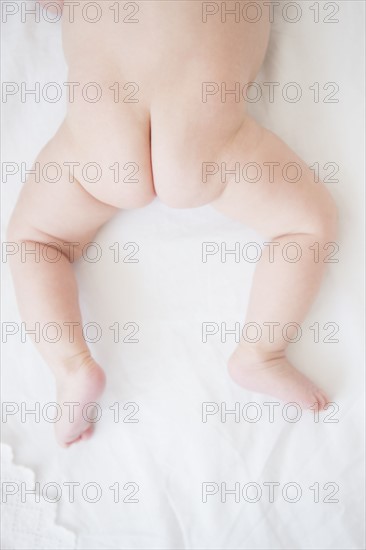 Baby girl (2-5 months) crouching on bed