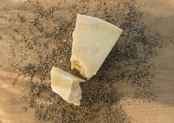 Studio shot of parmesan cheese on dried herbs