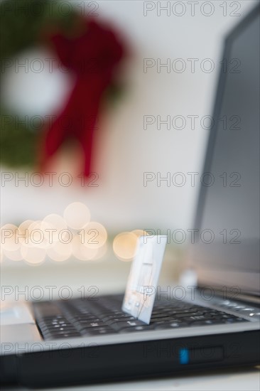 Laptop with credit card and Christmas decoration in background