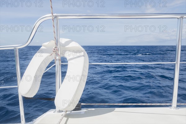 View from luxury yacht with railing and lifebelt in foreground
