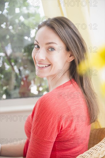 Portrait of smiling woman near window