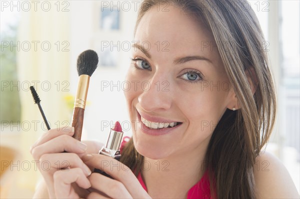 Portrait of woman with make up utensils