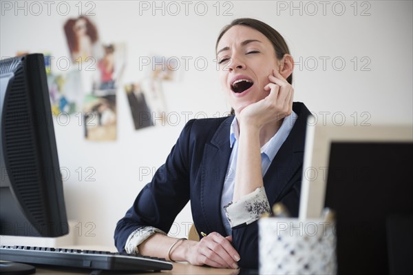 Woman yawning in office