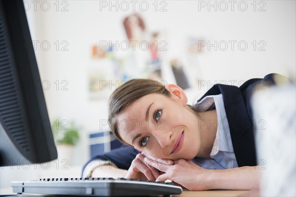 Woman leaning on her desk in office