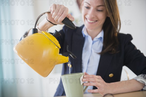 Woman making tea in office