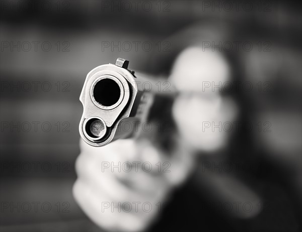 Man with handgun pointing towards camera