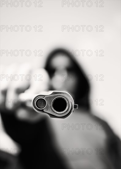 Man with handgun pointing towards camera