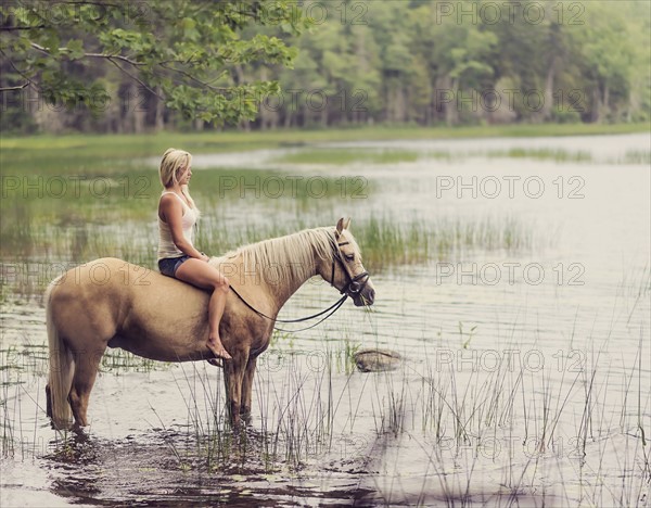 Woman horseback riding in countryside