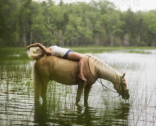 Woman horseback riding in countryside