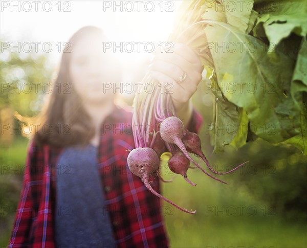 Woman holding bunch of radishes