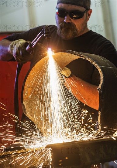 Welder working in metal workshop