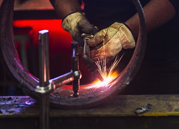 Welder working in metal workshop