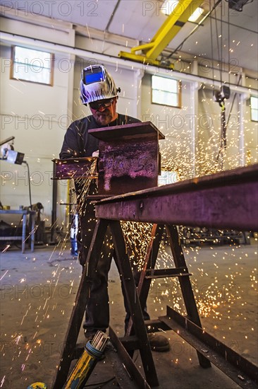 Welder working in metal workshop