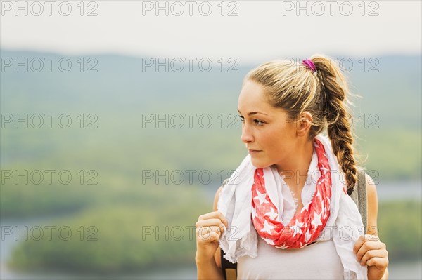 Portrait of young woman against green landscape