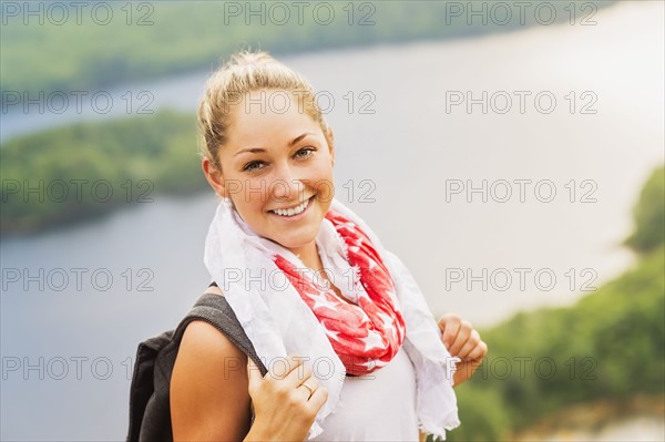 Smiley young woman against lake view