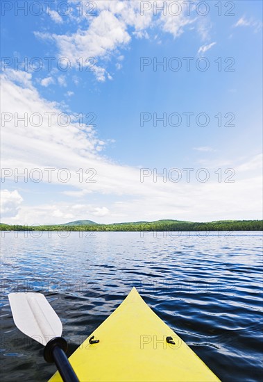 Bow of yellow kayak on lake