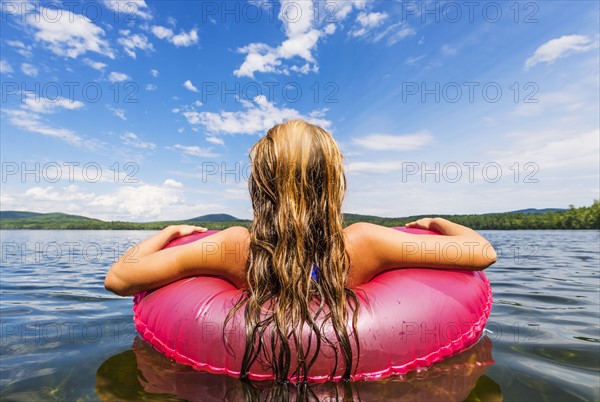 Young woman relaxing on lake in pool raft