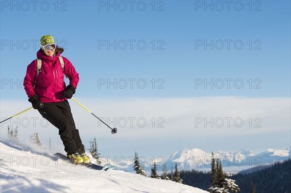 Mature woman on ski slope against sky