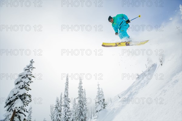 Young man jumping from ski slope