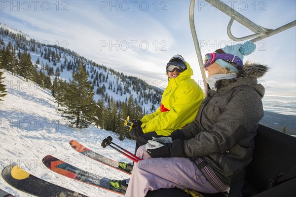 Couple in skiwear sitting on ski lift