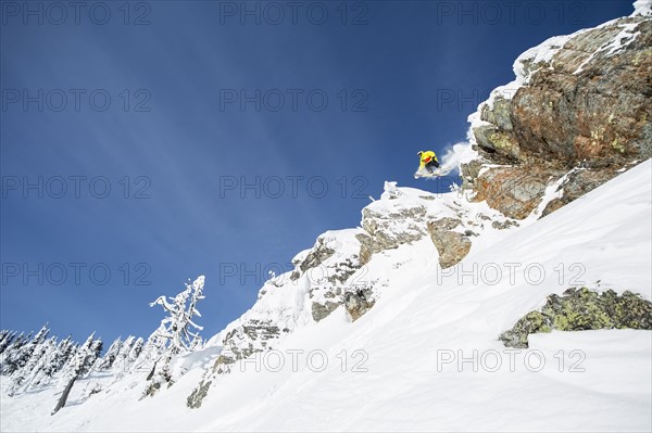 Young man jumping from ski slope