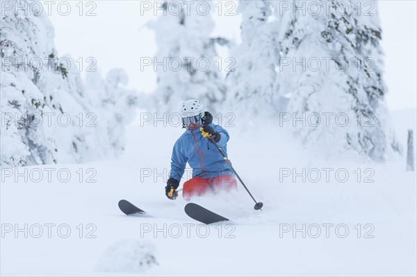 Mature man speeding on ski slope