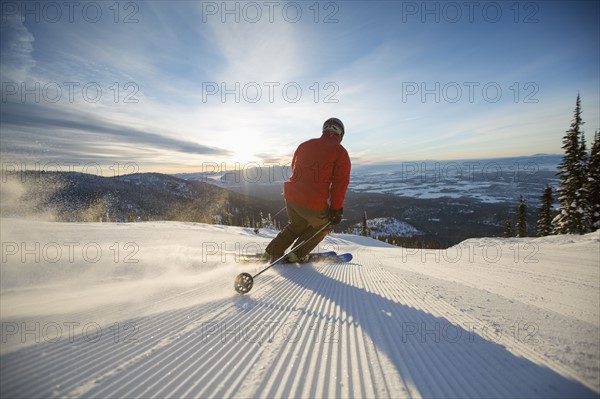 Mature man on ski slope at sunset