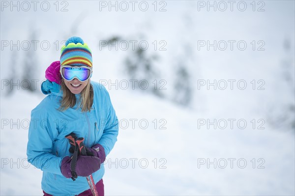 Smiley woman wearing skiwear on ski slope