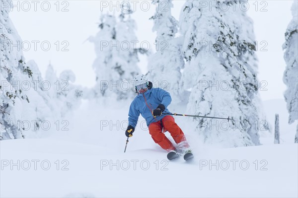 Mature man speeding on ski slope