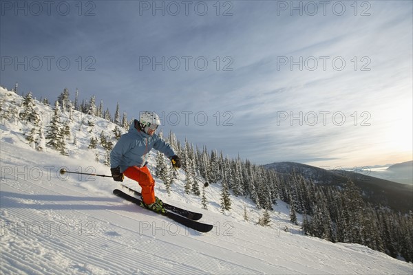 Mature man on ski slope at sunset
