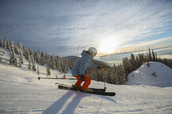 Mature man on ski slope at sunset