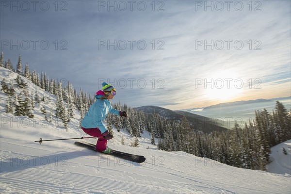 Mature woman on ski slope at sunset