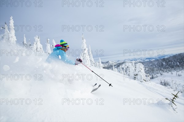 Mature woman speeding on ski slope