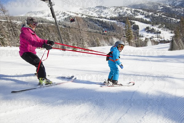 Mother teaching son (4-5) how to ski