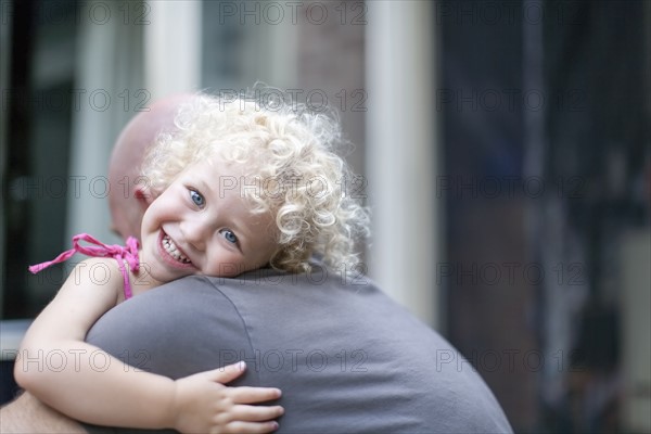 Smiley daughter (4-5) hugging father
