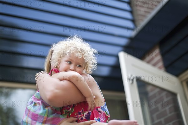 Smiley daughter (4-5) hugging mother