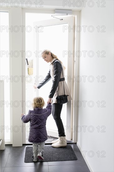Young woman leaving house with sister (4-5)