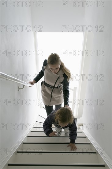 Mother and son (4-5) walking up stairs